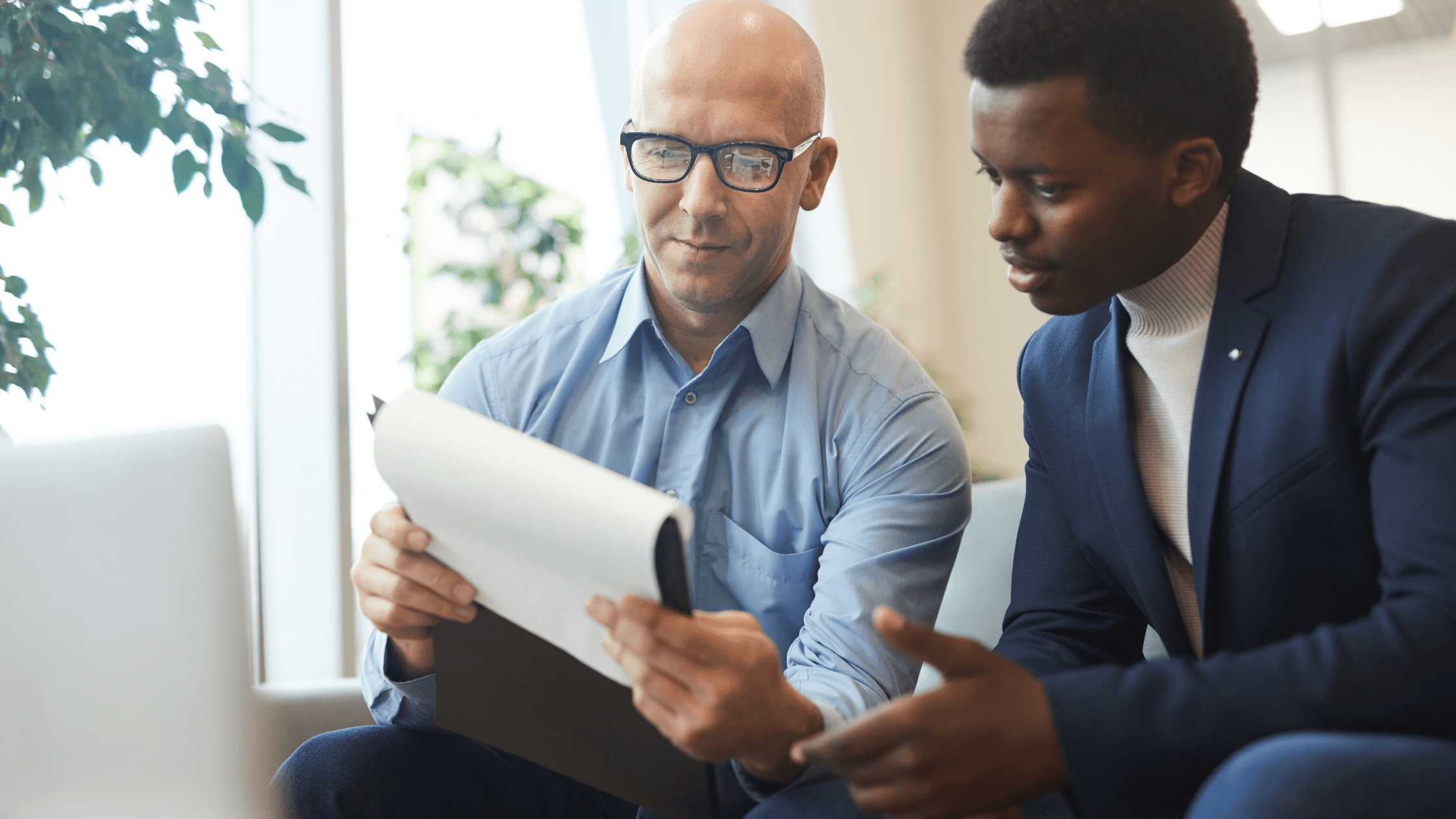 Business owner and advisor reviewing financial documents during the due diligence process before a company sale