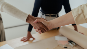 Two business partners shaking hands after agreeing on the timeline to sell a business
