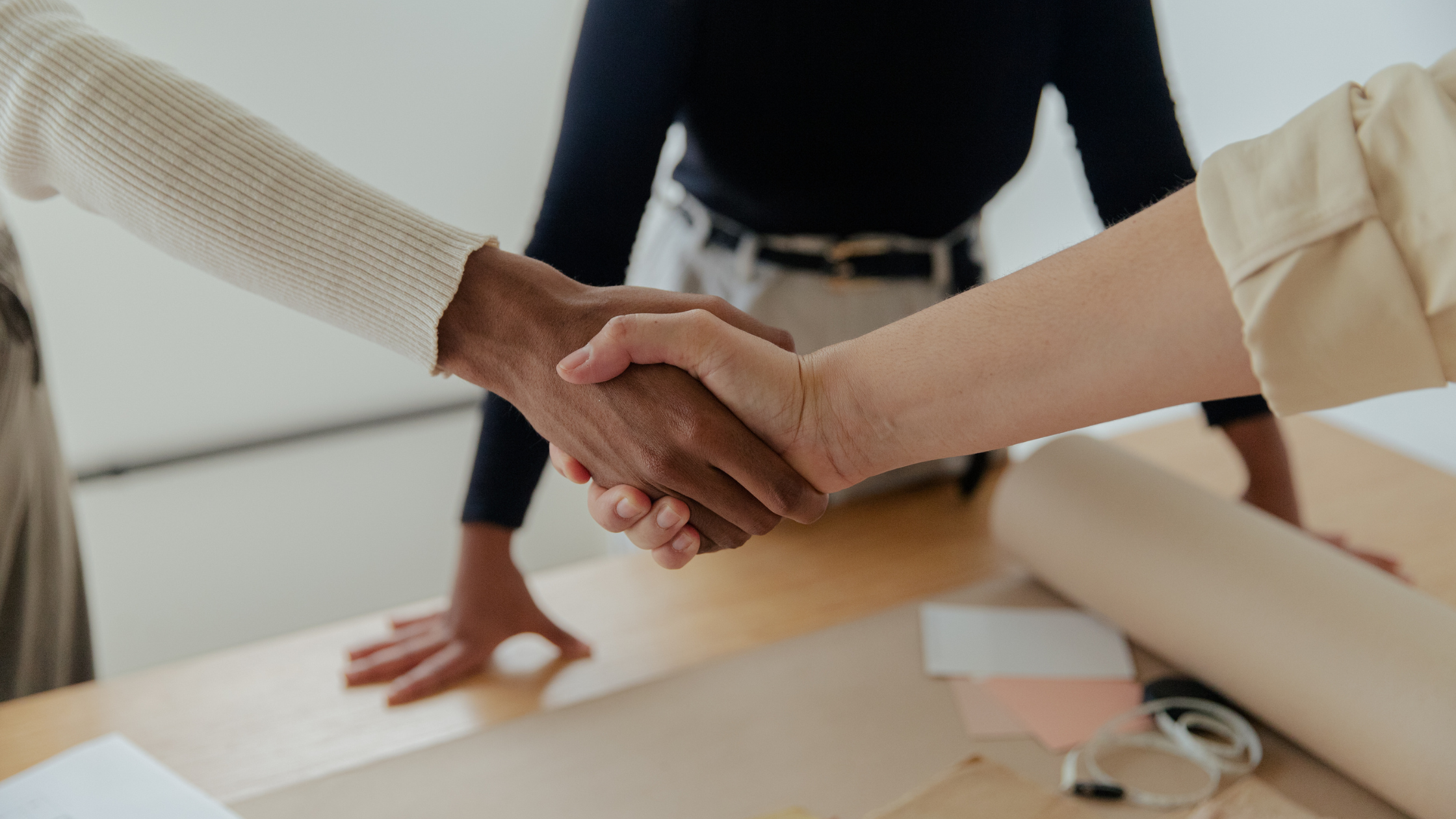 Two business partners shaking hands after agreeing on the timeline to sell a business